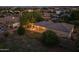 Night aerial view features backyard patio with string lights, desert landscaping, and stunning desert views at 21228 E Excelsior Ave, Queen Creek, AZ 85142
