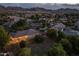 Nighttime aerial view of a home with backyard string lights, desert landscaping, and mountain views at 21228 E Excelsior Ave, Queen Creek, AZ 85142