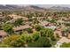 Expansive aerial view highlights the lush landscaping, surrounding homes, and mountain backdrop of the property at 21228 E Excelsior Ave, Queen Creek, AZ 85142