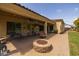 Lovely backyard with a brick patio, hanging lights, and a charming stone fire pit at 21228 E Excelsior Ave, Queen Creek, AZ 85142