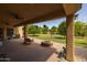 Inviting covered patio with brick flooring, cozy fire pit, and a spacious backyard view at 21228 E Excelsior Ave, Queen Creek, AZ 85142