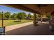 Large covered patio with brick pavers, string lights, ceiling fans, and a view of the spacious backyard at 21228 E Excelsior Ave, Queen Creek, AZ 85142