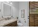 Bathroom featuring granite countertop, wood cabinets, decorative mirror, and shutters on the window at 21228 E Excelsior Ave, Queen Creek, AZ 85142