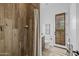 Bathroom showcasing wood-look tile, a glass-enclosed shower, and a toilet next to a door at 21228 E Excelsior Ave, Queen Creek, AZ 85142