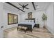 Bedroom featuring exposed beam ceiling, wood floors, and natural light from the shuttered window at 21228 E Excelsior Ave, Queen Creek, AZ 85142