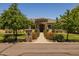 Charming home with a stone facade and beautiful landscaping leading to an arched entryway at 21228 E Excelsior Ave, Queen Creek, AZ 85142
