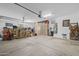 Spacious garage interior with storage cabinets, shelving, water heater, work benches, and overhead lighting at 21228 E Excelsior Ave, Queen Creek, AZ 85142