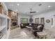 Open-concept living room with stone fireplace, beamed ceiling fan, and neutral color palette at 21228 E Excelsior Ave, Queen Creek, AZ 85142