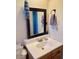 Bathroom vanity features a white countertop, wood cabinets, and decorative mirror at 2335 W Campus Dr, Phoenix, AZ 85015