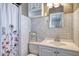 Simple bathroom with neutral-toned tiles, shower with curtain, and vanity at 2335 W Campus Dr, Phoenix, AZ 85015