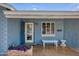 Inviting front porch featuring brick accents, blue exterior, white bench, and potted plants at 2335 W Campus Dr, Phoenix, AZ 85015