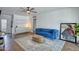 Relaxing living room featuring a plush blue sofa, modern fan, and decorative rug at 2335 W Campus Dr, Phoenix, AZ 85015