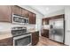 A well-equipped kitchen with stainless steel appliances, dark wood cabinetry, and granite countertops at 2668 N 73Rd Gln, Phoenix, AZ 85035