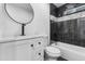 Bathroom features a vanity, toilet, and shower-tub combo with black tiling at 3002 W Mandalay Ln, Phoenix, AZ 85053
