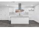 An all-white kitchen features a large island, modern backsplash, and bright lighting at 3002 W Mandalay Ln, Phoenix, AZ 85053