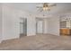Large carpeted bedroom featuring a ceiling fan, closet and open view to the bathroom at 3150 E Beardsley Rd # 1091, Phoenix, AZ 85050