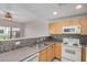 Functional kitchen featuring oak cabinets, tile backsplash, and white appliances at 3150 E Beardsley Rd # 1091, Phoenix, AZ 85050
