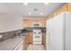 Well-lit kitchen features oak cabinets, tile backsplash, and white appliances at 3150 E Beardsley Rd # 1091, Phoenix, AZ 85050