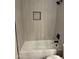 The bathroom has a shower and bathtub with modern tile and sleek, black fixtures at 3517 E Blanche Dr, Phoenix, AZ 85032