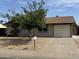 Charming single-story home featuring a well-maintained yard with stone landscaping, a large shade tree, and a white single car garage at 3517 E Blanche Dr, Phoenix, AZ 85032