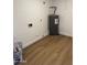 Utility room with new laminate floors, a water heater, and plumbing hookups at 3517 E Blanche Dr, Phoenix, AZ 85032