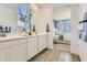 Elegant bathroom with double vanities offering serene bedroom views at 36545 W Maddaloni Ave, Maricopa, AZ 85138