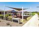 Community playground with climbing equipment, swings, and sunshades for a fun outdoor experience at 36545 W Maddaloni Ave, Maricopa, AZ 85138