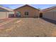 Wide shot of a spacious backyard with easy to maintain rock and a charming covered patio at 40168 W Sanders Way, Maricopa, AZ 85138