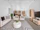 Bright living room featuring modern furniture, neutral tones, and an open concept design leading into the kitchen and dining area at 40168 W Sanders Way, Maricopa, AZ 85138
