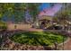 Expansive backyard with gravel, covered patio, privacy fence, and a circular lawn at 42406 W Posada Dr, Maricopa, AZ 85138