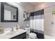 The bathroom offers a bathtub, shower, black framed mirror and vanity for a refreshed and modern design at 42406 W Posada Dr, Maricopa, AZ 85138