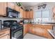 Functional kitchen featuring black appliances, granite countertops, and light wood cabinetry at 42406 W Posada Dr, Maricopa, AZ 85138