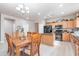 Open kitchen with an island, granite countertops, wooden cabinets, and a dining table with seating at 42406 W Posada Dr, Maricopa, AZ 85138