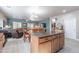 Stylish kitchen island with granite countertop, wooden cabinetry, and open floor plan connecting to the living room at 42406 W Posada Dr, Maricopa, AZ 85138