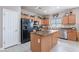 This kitchen features an island, stainless steel appliances, and light wood cabinets at 42406 W Posada Dr, Maricopa, AZ 85138