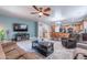 Open-concept living room flows into a kitchen with dark appliances, wood cabinets, and a dining area at 42406 W Posada Dr, Maricopa, AZ 85138