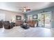 Spacious living room with comfortable seating, ceiling fan, and sliding glass doors for natural light at 42406 W Posada Dr, Maricopa, AZ 85138