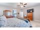 This primary bedroom boasts a ceiling fan, TV and a connected bathroom for added comfort and convenience at 42406 W Posada Dr, Maricopa, AZ 85138