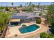 Single-Gathering home featuring a swimming pool, covered patio, solar panels, and mature landscaping at 511 E Port Au Prince Ln, Phoenix, AZ 85022