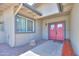 A lovely covered front entryway with a welcoming red double door, desert rock landscaping and seating at 511 E Port Au Prince Ln, Phoenix, AZ 85022