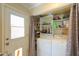 Bright laundry area features washer, dryer, storage shelves and exterior access at 511 E Port Au Prince Ln, Phoenix, AZ 85022
