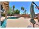 Backyard pool area showcasing lush palm trees, a brick wall, and well-maintained landscaping at 511 E Port Au Prince Ln, Phoenix, AZ 85022
