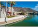 Lakeside backyard featuring a boat dock, patio area, lush greenery, and a scenic view at 5281 W Quail Ave, Glendale, AZ 85308