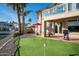Backyard featuring an artificial grass putting green, an outdoor kitchen area, and waterfront access at 5281 W Quail Ave, Glendale, AZ 85308