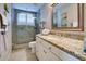 Bathroom with granite countertops, a mirror, a walk-in shower, and white cabinets at 5281 W Quail Ave, Glendale, AZ 85308