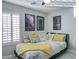 Bedroom featuring a ceiling fan, comfortable bed with decorative pillows, and bright shuttered windows at 5281 W Quail Ave, Glendale, AZ 85308