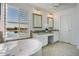 Bright bathroom with a large soaking tub, double vanity, and a water view at 5281 W Quail Ave, Glendale, AZ 85308