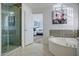 Bathroom featuring a glass shower and jetted tub at 5281 W Quail Ave, Glendale, AZ 85308