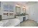 Bright bathroom with a large soaking tub, double vanity, and a water view at 5281 W Quail Ave, Glendale, AZ 85308