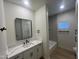 The bathroom is equipped with black hardware, white cabinets, and a modern shower-tub combo at 5635 S 11Th Dr, Phoenix, AZ 85041